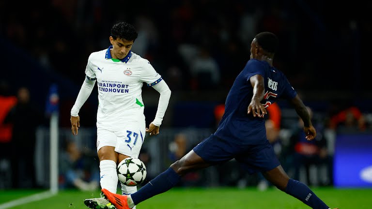 Paris St Germain's Nuno Mendes in action with PSV Eindhoven's Richard Ledezma - Photo Credit : REUTERS