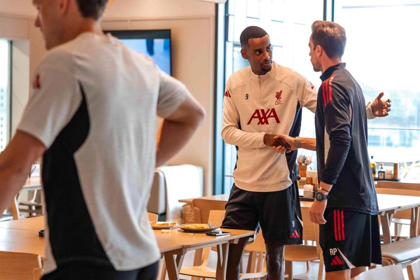 Alexander Isak with one of Liverpool's backroom crew during his first training session at the AXA centre on Wednesday. (Credit: Liverpool media.)