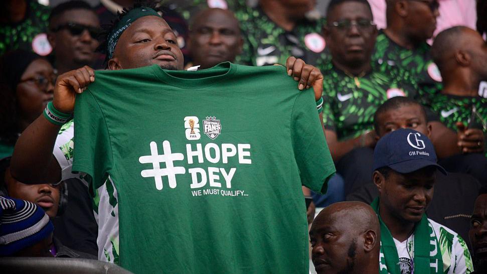 Nigerian Fan with Tshirt branded Hope Day we must Qualify ahead of 2026 world Cup - Photo credit : BBC