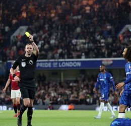 Manchester United's Noussair Mazraoui is shown a yellow card by referee Chris Kavanagh as Chelsea's Levi Colwill reacts on the ground - Photo Credit : Reuters